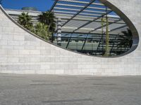 a person riding on a skateboard in front of a building with a big curved building