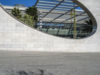 a person riding on a skateboard in front of a building with a big curved building