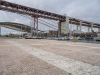 many boats are docked at the shore under a bridge that's made of concrete bricks