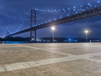 there is a night view of the bridge and city lights that shine on the ground