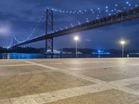 there is a night view of the bridge and city lights that shine on the ground