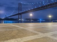 there is a night view of the bridge and city lights that shine on the ground