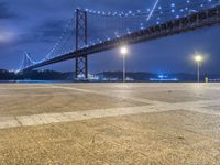 there is a night view of the bridge and city lights that shine on the ground