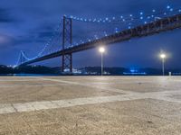 there is a night view of the bridge and city lights that shine on the ground