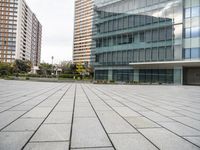 an empty concrete and glass building with cars parked in front of it on a sunny day