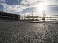 a brick walkway leads to a dock near an empty parking lot on the waterfront area