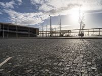 a brick walkway leads to a dock near an empty parking lot on the waterfront area