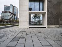 the building's exterior features a grey stone pattern on the outside, with windows, trees and benches surrounding