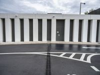 an empty parking lot has a closed entrance, which leads to two garage doors with closed spaces in it