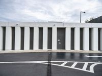 an empty parking lot has a closed entrance, which leads to two garage doors with closed spaces in it