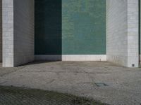 the corner of the building with the floor in the middle, the wall made from glass has tiles painted in blue, green, and white and silver, and black