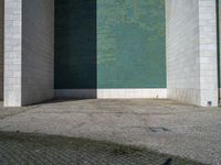 the corner of the building with the floor in the middle, the wall made from glass has tiles painted in blue, green, and white and silver, and black