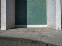 the corner of the building with the floor in the middle, the wall made from glass has tiles painted in blue, green, and white and silver, and black