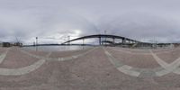 a fish eye view of a bridge and some clouds in the background on a cloudy day