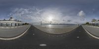 an upside down picture shows the street in front of the bridge and ocean with clouds in the sky