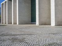 the corner of a concrete building is clearly visible on the ground, and there are two people walking past