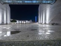 the lights are dimmed on a large walkway outside of a building at night time