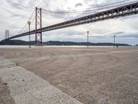 a tall metal suspension bridge across a body of water with a lot of traffic below it