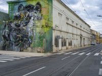 a painting on a green wall by a busy street and train tracks in the city