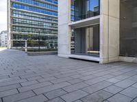 an empty concrete sidewalk in front of an apartment building with glass doors on both sides