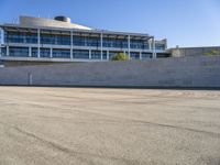 a building next to a road that is empty and has concrete bricks and grey steps