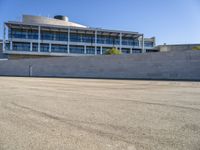 a building next to a road that is empty and has concrete bricks and grey steps