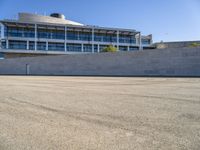 a building next to a road that is empty and has concrete bricks and grey steps