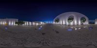 this is a reflection of a building on a cobblestone floor at night, showing the dome entrance and entrance way