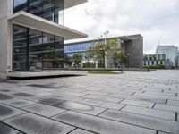 a view of a courtyard with a stone floor and glass walls from the building's side