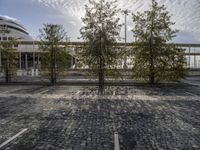 empty parking space, with trees and white building in the back ground and sky behind