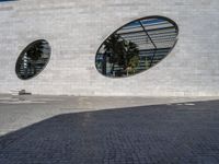 the building is white brick with two round windows, as if to be reflected on glass