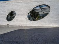 the building is white brick with two round windows, as if to be reflected on glass