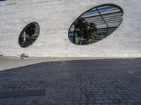 the building is white brick with two round windows, as if to be reflected on glass