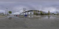 an empty skateboard park with multiple ramps and bridges above water level with clouds in the sky