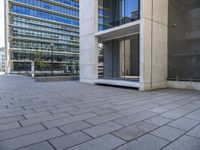 a large building that has lots of windows and stone pavement near it's outside