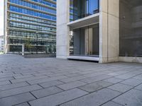 a large building that has lots of windows and stone pavement near it's outside