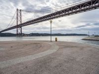 there is a view of the bridge from the beach in spain under it, and it's almost empty