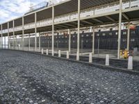 a large building is sitting in the middle of an empty street that has several poles