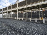 a large building is sitting in the middle of an empty street that has several poles