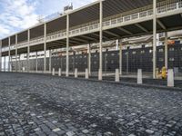 a large building is sitting in the middle of an empty street that has several poles