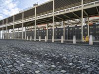 a large building is sitting in the middle of an empty street that has several poles