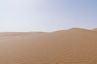 a desert with some sand in it and the sky above it in the background, the sun is shining