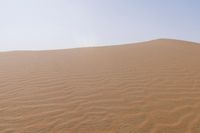 a desert with some sand in it and the sky above it in the background, the sun is shining