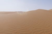 a desert with some sand in it and the sky above it in the background, the sun is shining