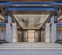 the lobby of a large hotel with seating on one step and an open door leading into the lobby