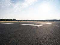 a lone jet landing on the runway at the airport as sun hits in the sky