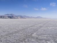 there is a lone motorcycle parked in the desert, with mountains in the background, and no one on the side