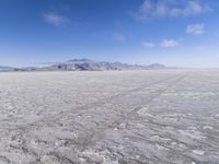 there is a lone motorcycle parked in the desert, with mountains in the background, and no one on the side