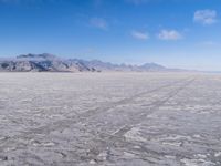 there is a lone motorcycle parked in the desert, with mountains in the background, and no one on the side