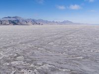 there is a lone motorcycle parked in the desert, with mountains in the background, and no one on the side